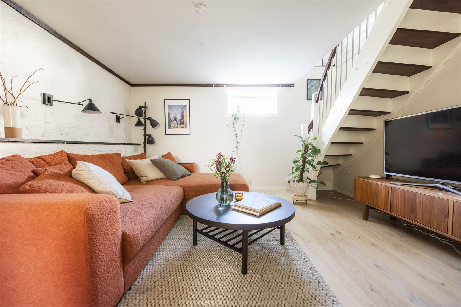 - Kjellerstuen er delt i soner med sofasone, tv-benk og hyggelig peis - Galleribilde