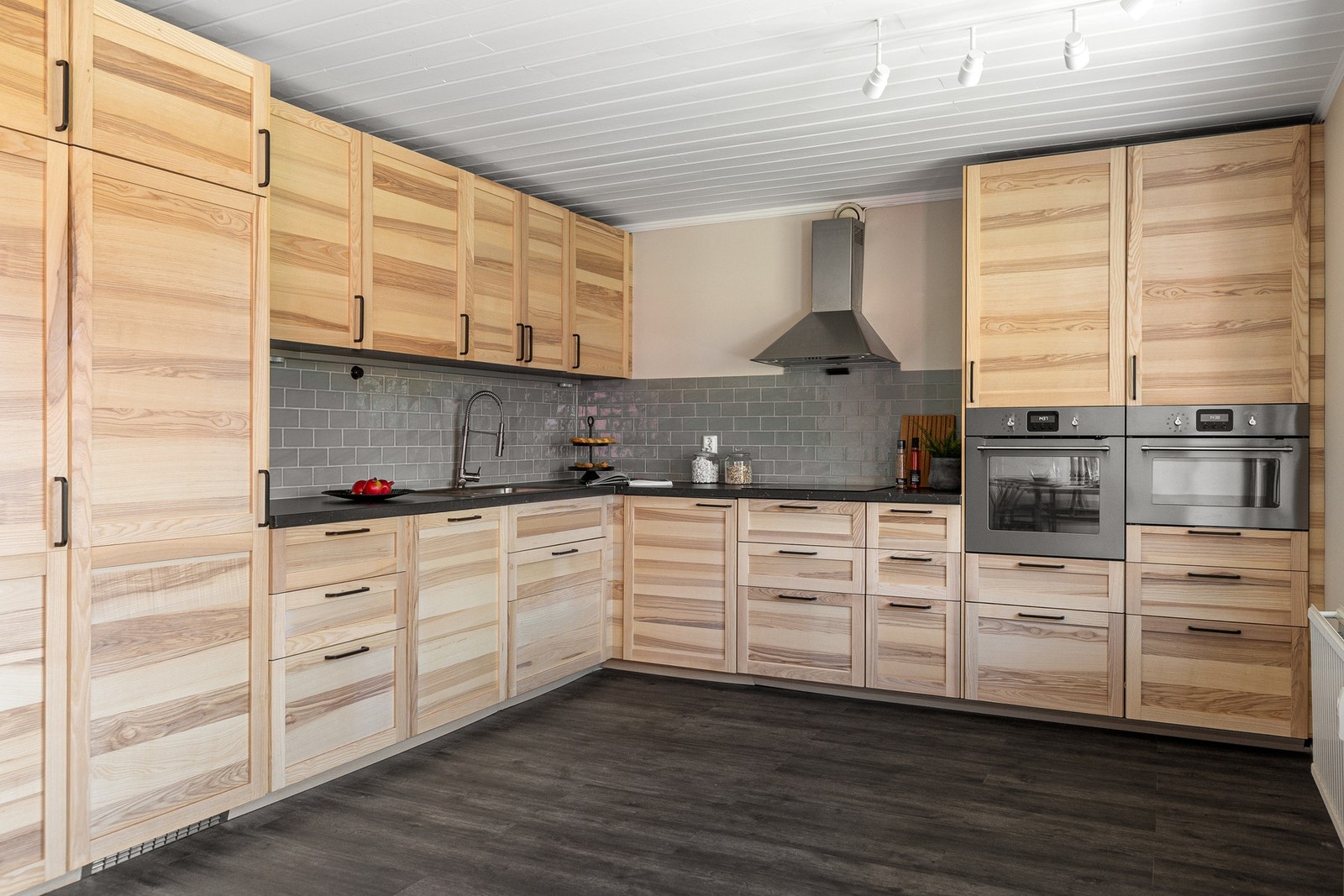 Pent og funksjonelt kjøkken fra IKEA innredet med profilerte fronter og laminert benkeplate. Galleribilde
