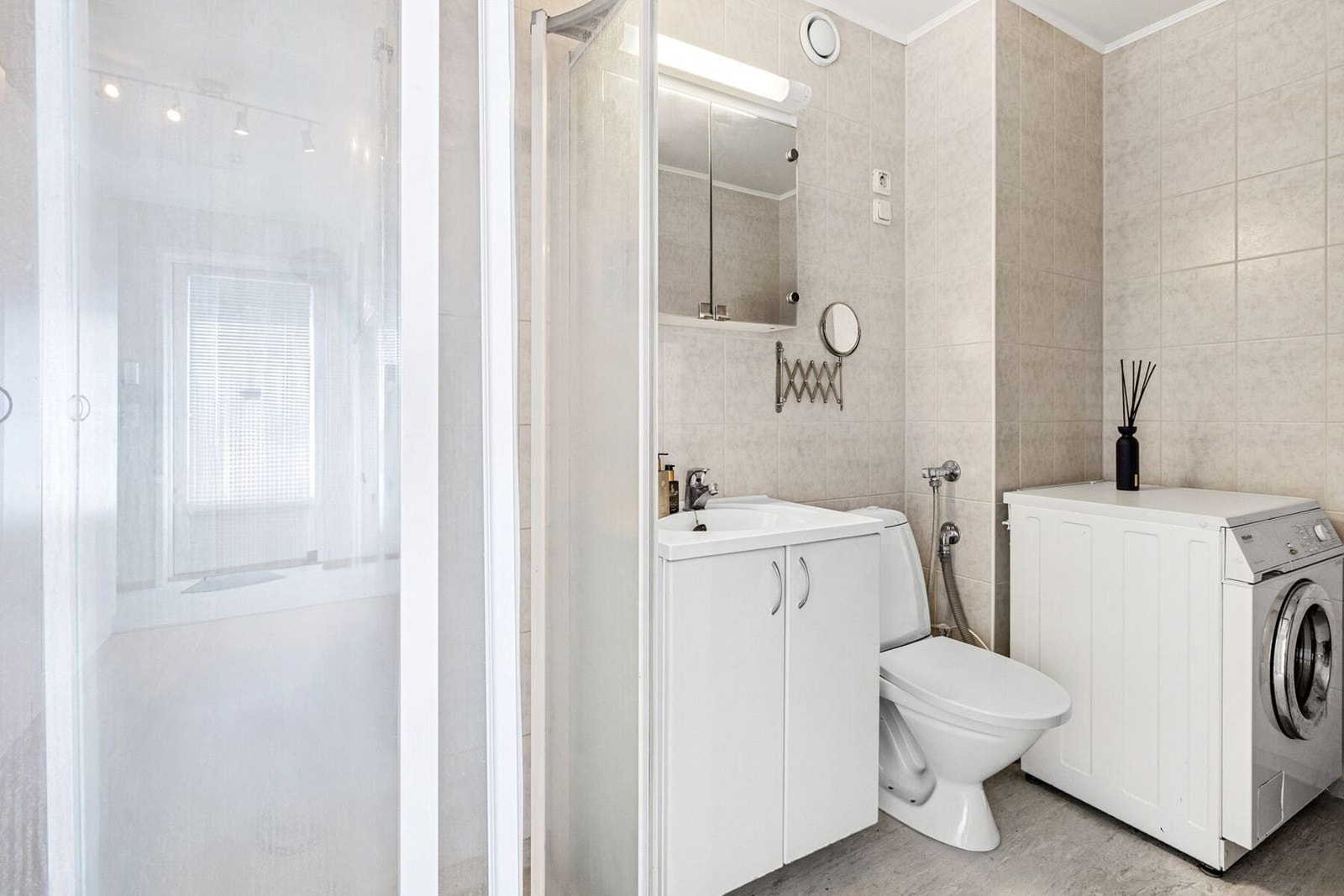 Badet er funksjonelt utformet med dusjkabinett, toalett, servant og vaskemaskin. Her er alt du trenger på ett sted. Galleribilde