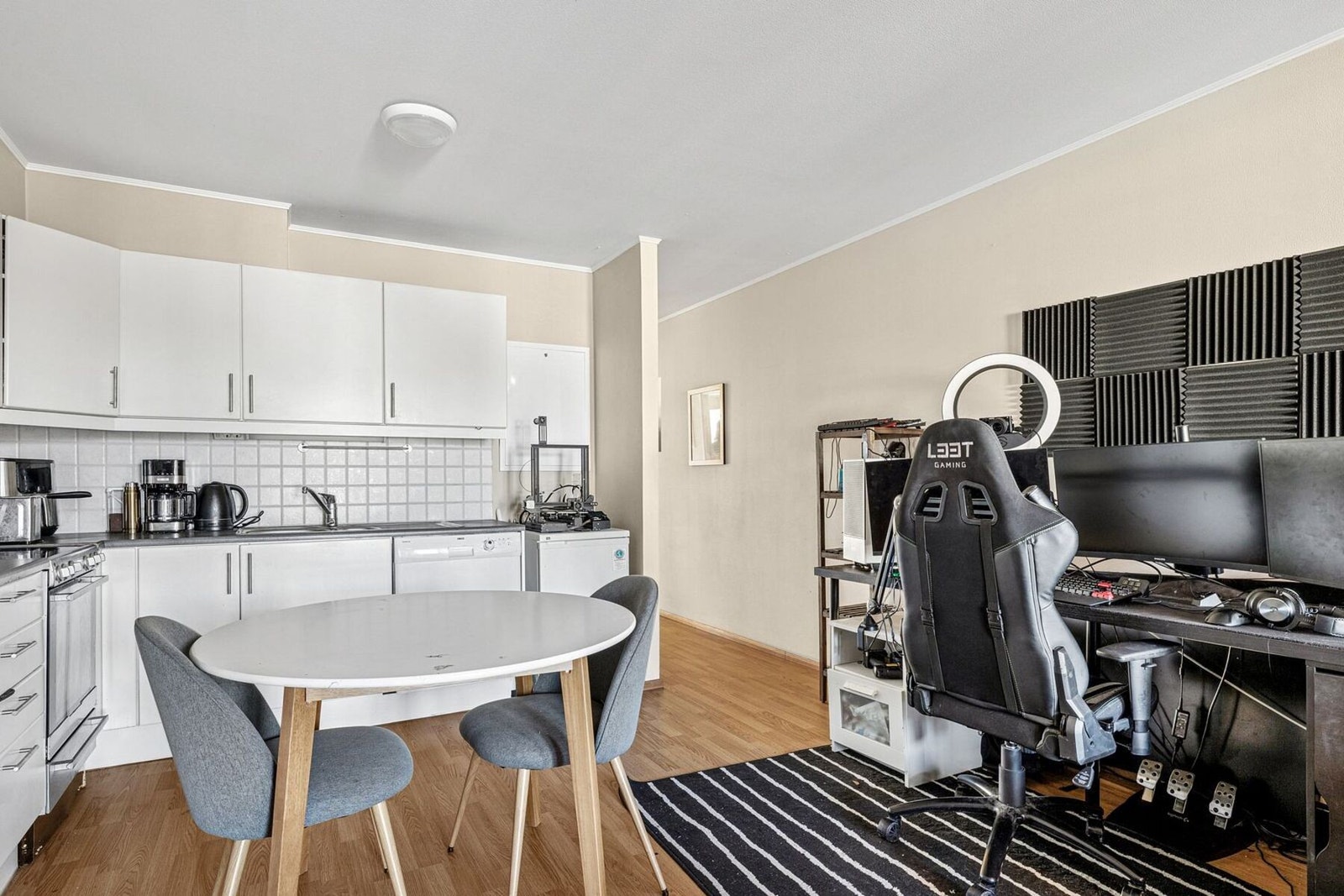 Kjøkkenet har en enkel og funksjonell utforming med hvite fronter, flislagt vegg og plass til spisebord. Galleribilde