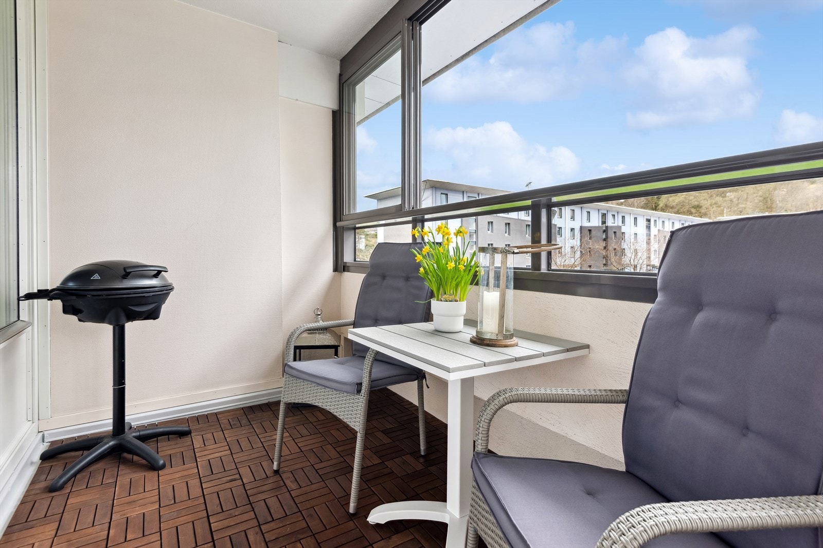 Utgang fra stuen til innglasset balkong. Fra balkongen har man behagelig utsikt over borettslagets grøntarealer, og sol til ca kl 21:30. Galleribilde