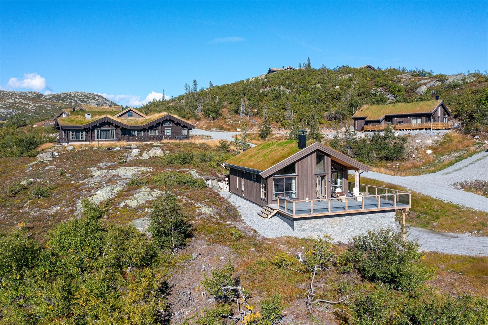 Hytta ligger i front i terrenget Galleribilde