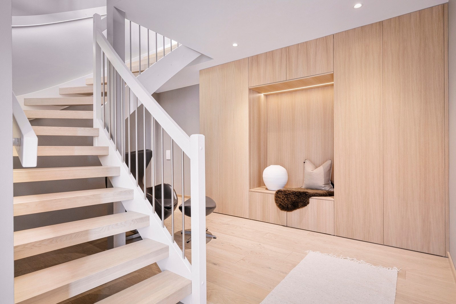 Yttertøyet ryddes enkelt bort i en stor, plassbygd garderobeløsning, og i trappen opp til andre etasje er det stilfull designbelysning. Galleribilde