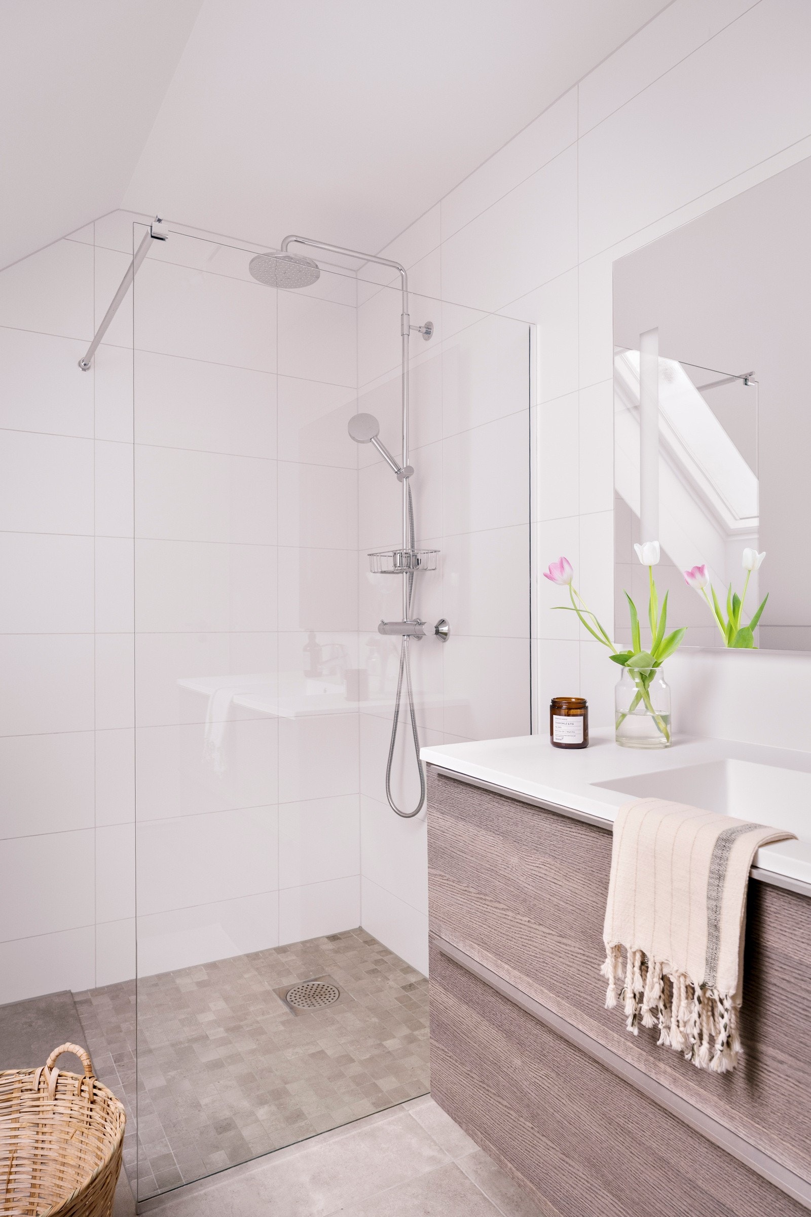 Baderomsinnredningen fra Kvik har mørke, finerte fronter og består av en heldekkende servant på en skuffeseksjon og et stort speil med integrert belysning. Galleribilde