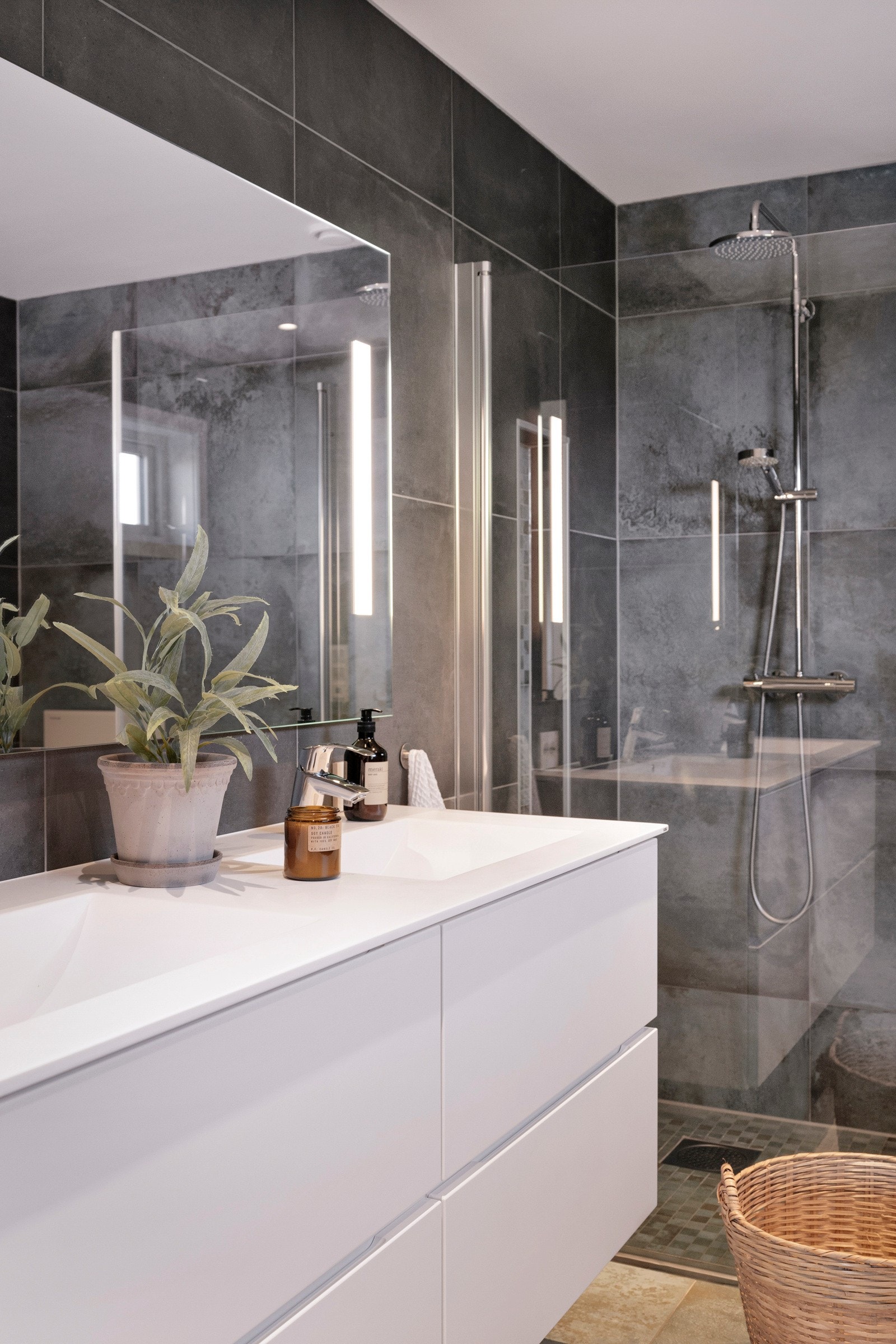 Her er det store, koksgrå fliser på veggene, downlights i himlingen og store, kobberfargede fliser på gulv med gulvvarme. Galleribilde