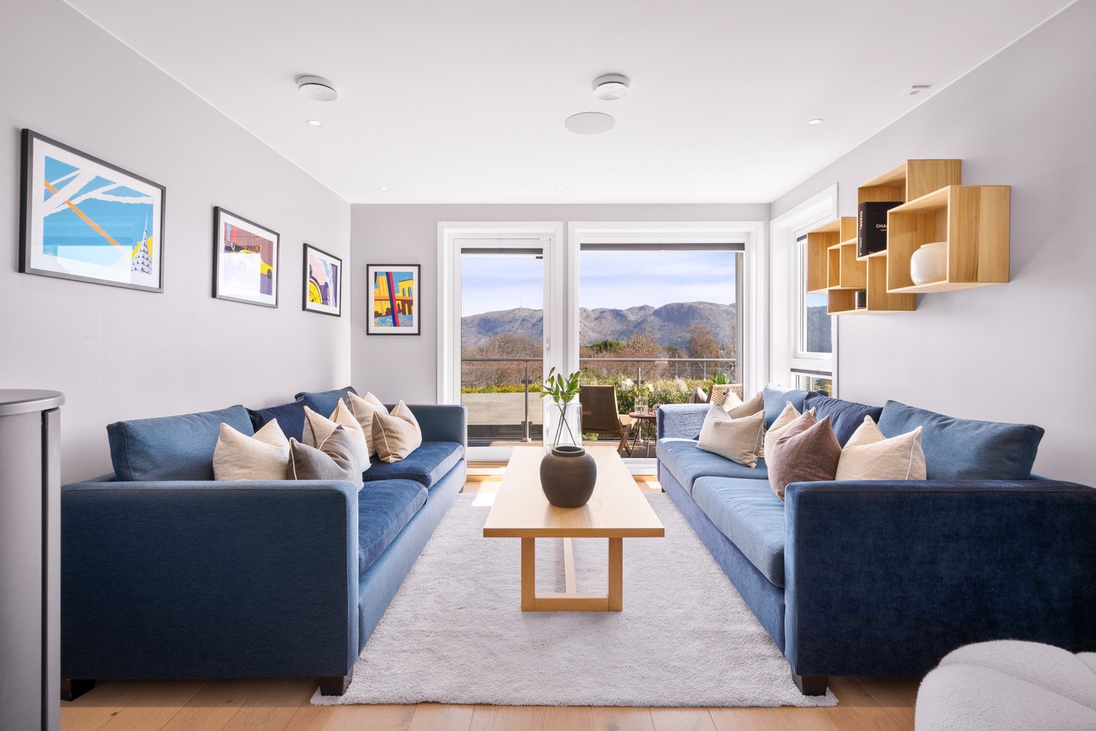 Stuen er holdt i en stilren kombinasjon med lysmalte vegger mot gyllent, enstavs parkettgulv, og det er listfrie overganger til hvit himling. Galleribilde