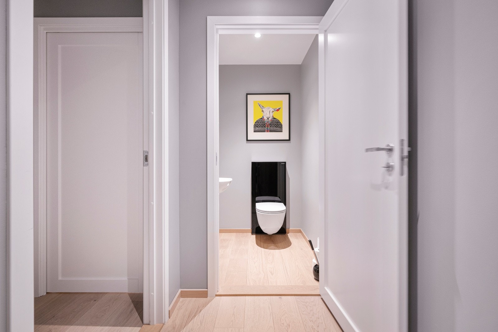 I tilknytning til hallen i underetasjen er det et pent, separat wc-rom med glatte, lysmalte vegger, downlights i himlingen og enstavs parkett på gulvet. Wc-rommet har vegghengt toalett og en enkel servant. Galleribilde