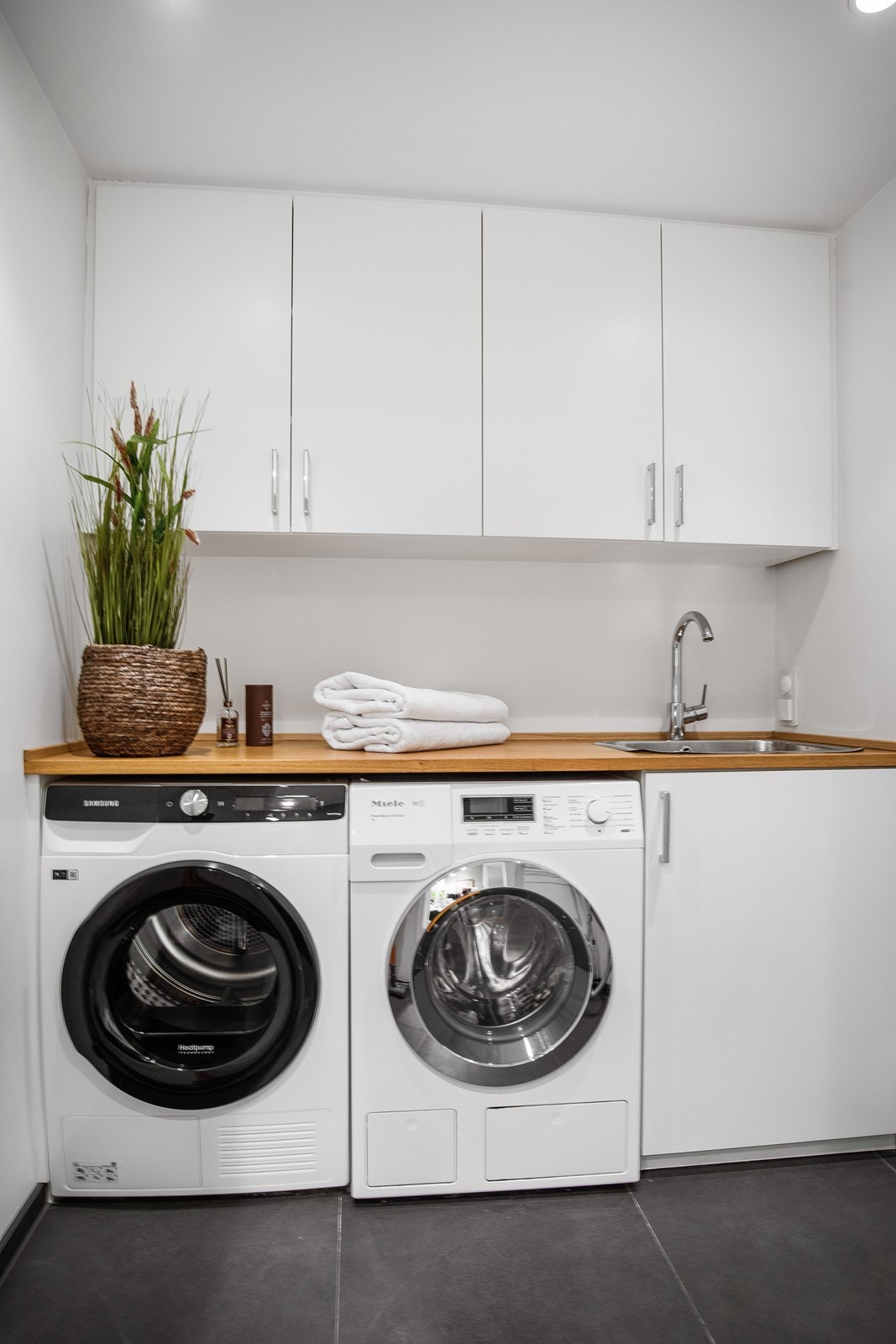 Romslig vaskerom med brettebenk og utslagsvask. Galleribilde