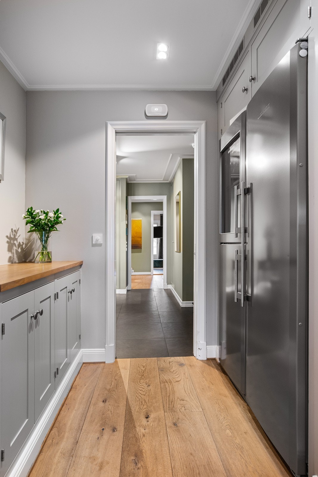 Grovkjøkken mellom entré og kjøkkenet, kjøleskap, fryseskap og vinskap, samt benk for anretning. Galleribilde