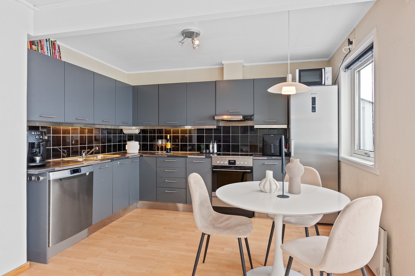 Kjøkkeninnredning med glatte fronter. God plass til oppbevaring i skuffer og skap. Galleribilde