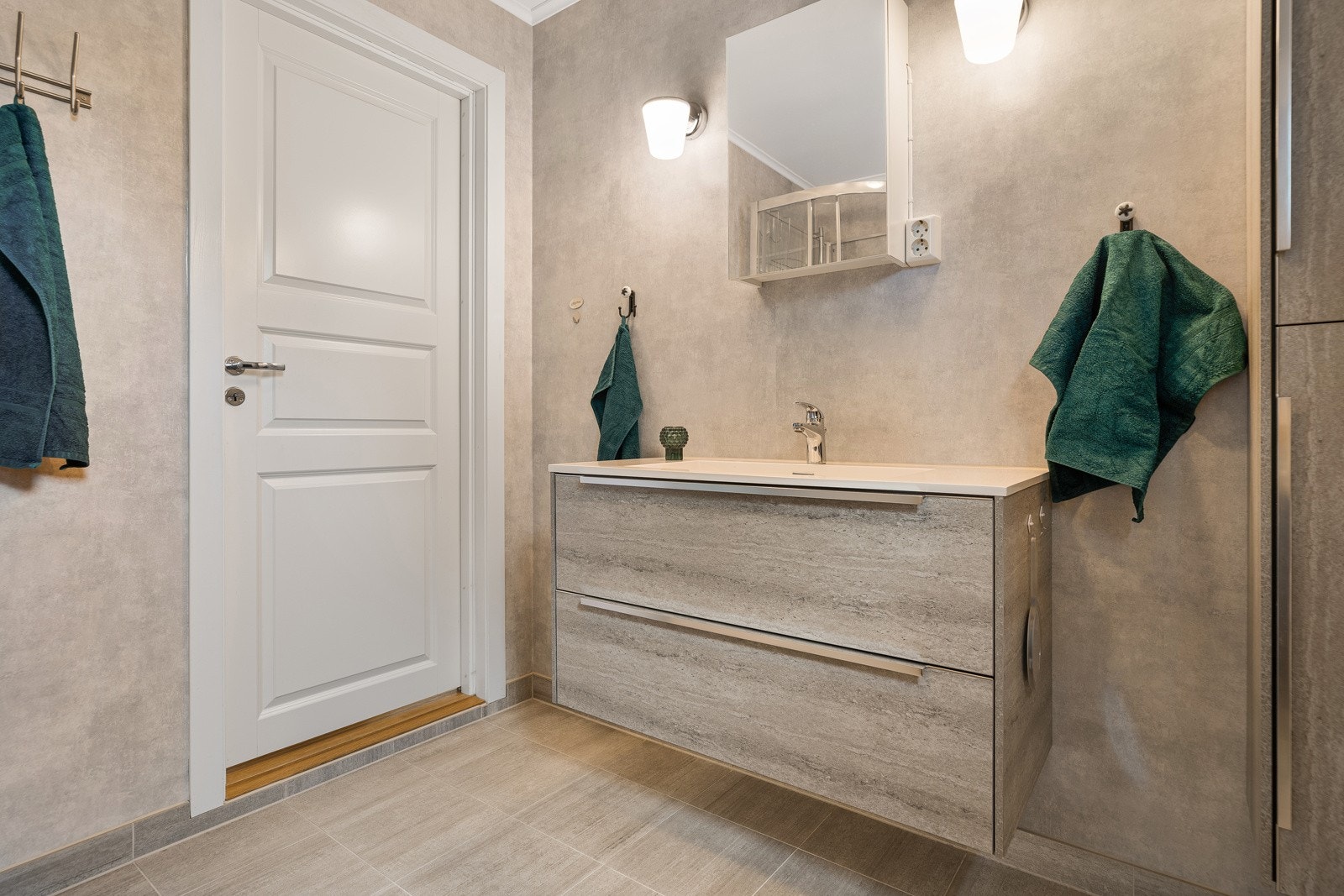 Baderomsinnredningen gir god plass til oppbevaring av håndklær og hygieneartikler. Galleribilde