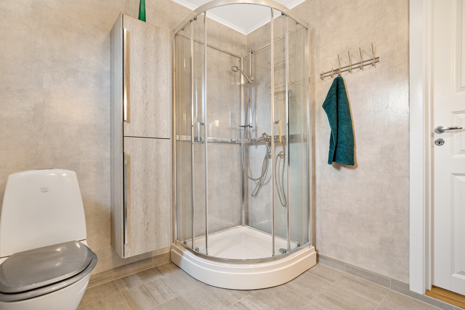 Badet er innredet med dusjkabinett, varmekabler og flislagt gulv. Galleribilde