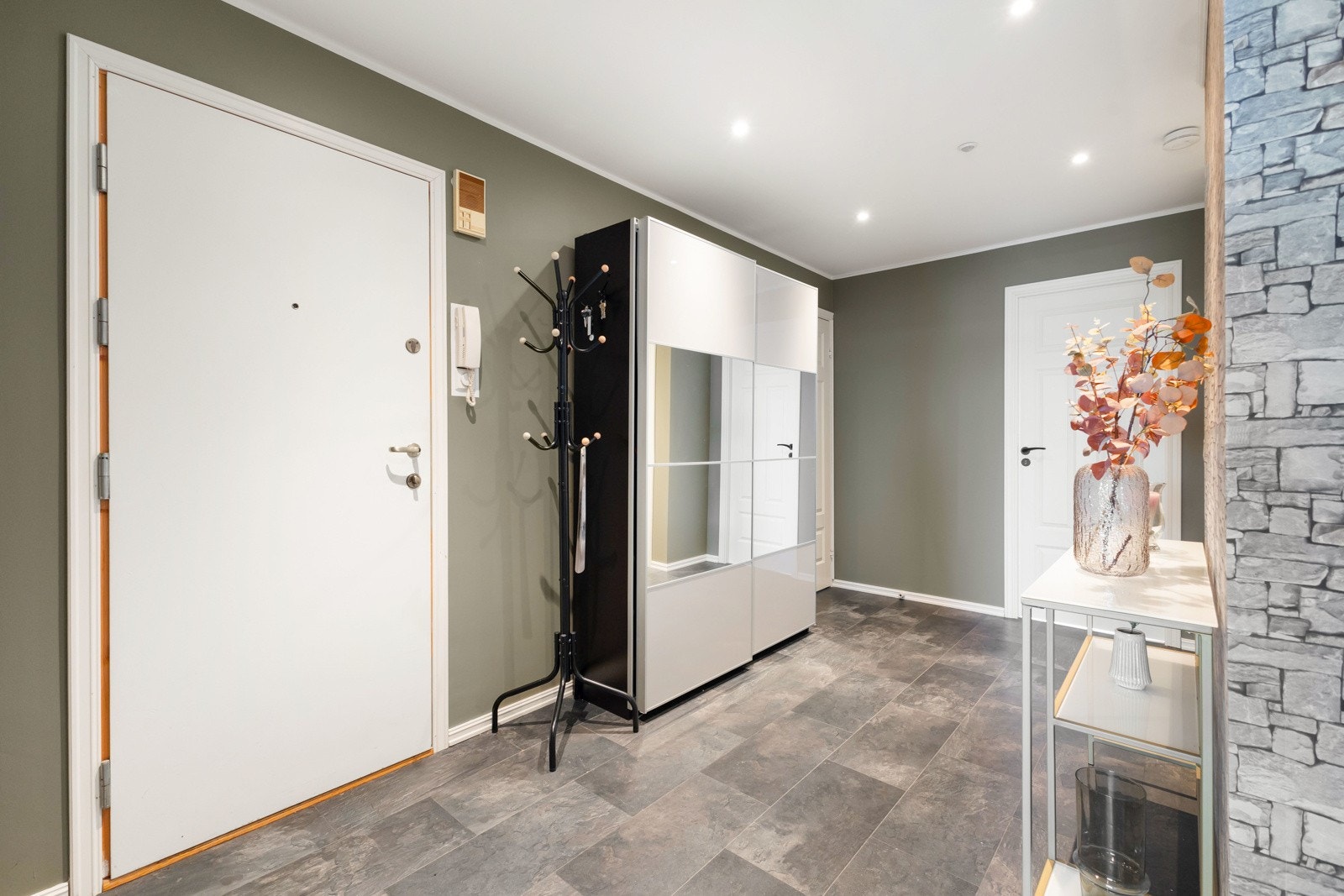 I entréen er det god plass til å sette fra seg sko og henge opp yttertøy, en stor skyvedørsgarderobe sørger for praktisk oppbevaring Galleribilde
