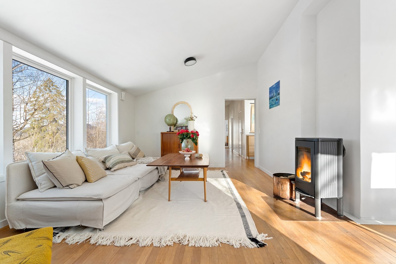 For ekstra komfort på kjølige dager er stuen utstyrt med både en effektiv varmepumpe og en stemningsfull peis som gir lun varme Galleribilde