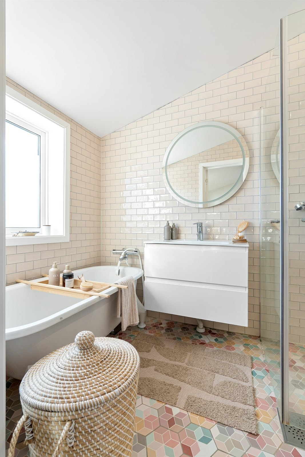 Her finner du både et innbydende badekar og et praktisk dusjhjørne med innfellbare glassdører, samt en hånd- og regndusj fra Mora Galleribilde