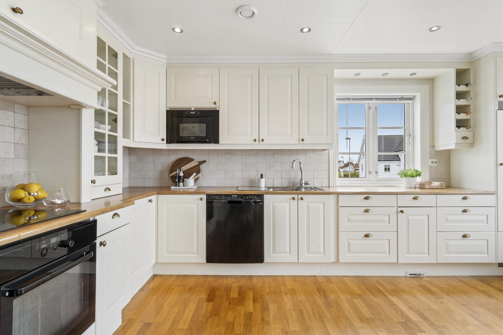 Pen og tidløs kjøkkeninnredning m/integrerte hvitevarer. Downlights i tak. Galleribilde