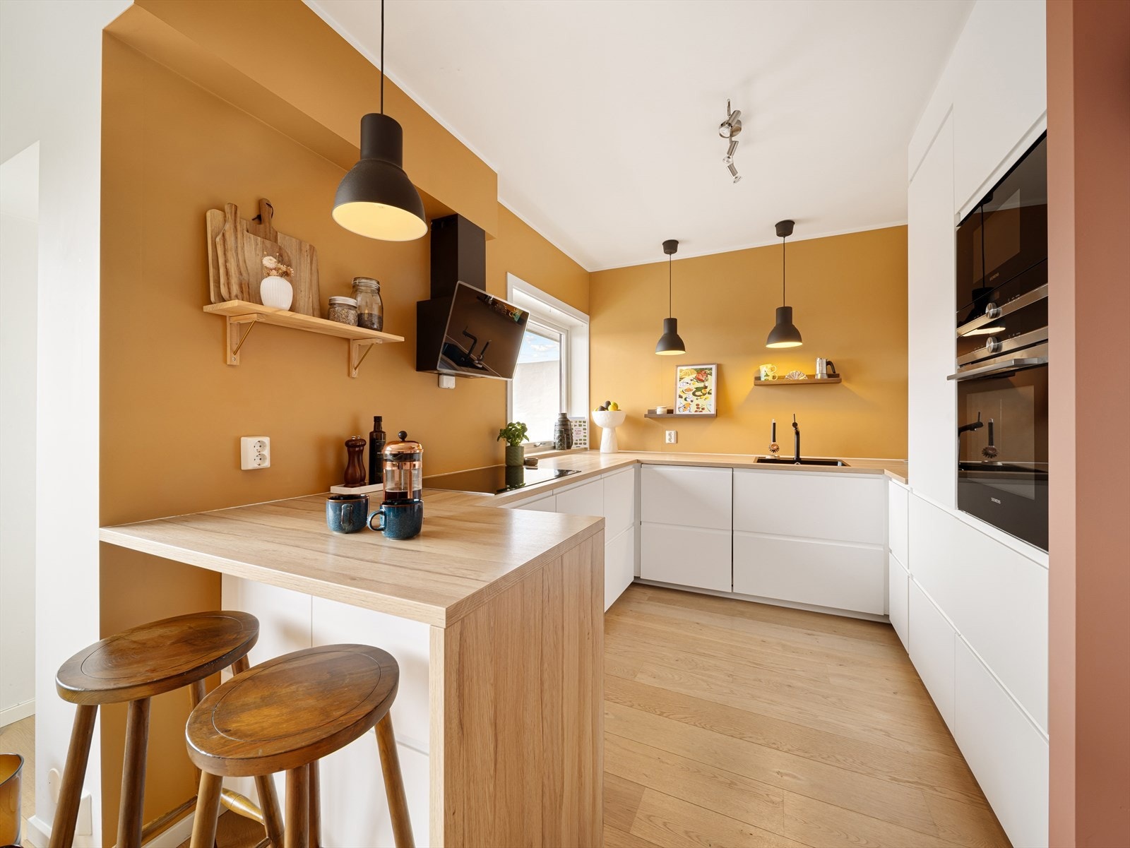 Kjøkkeninnredningen strekker seg over begge sider og gir rikelig med skuffe- og benkeplass. Ovn og mikrobølgeovn er praktisk plassert i høyskap, og vinduet på kjøkkenet slipper inn naturlig lys Galleribilde