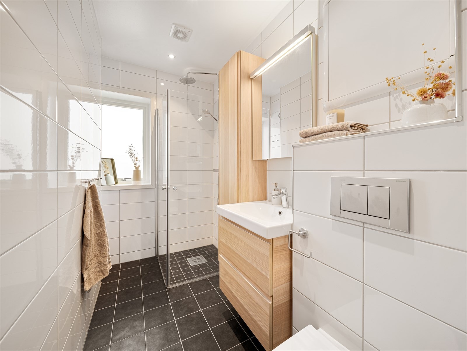 Det er utstyrt med vegghengt toalett, møblement med servant, høyskap og skap med speilfront, samt varmekabler på gulvet Galleribilde