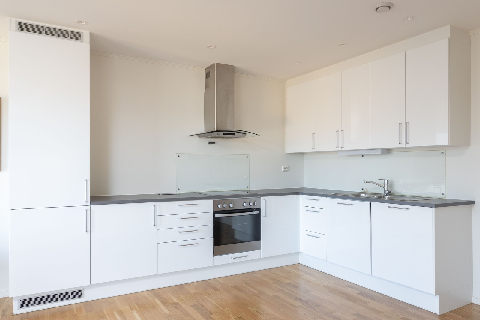 Kjøkkeninnredning med integrert stekeovn, platetopp, oppvaskmaskin og kjøl-/fryseskap Galleribilde