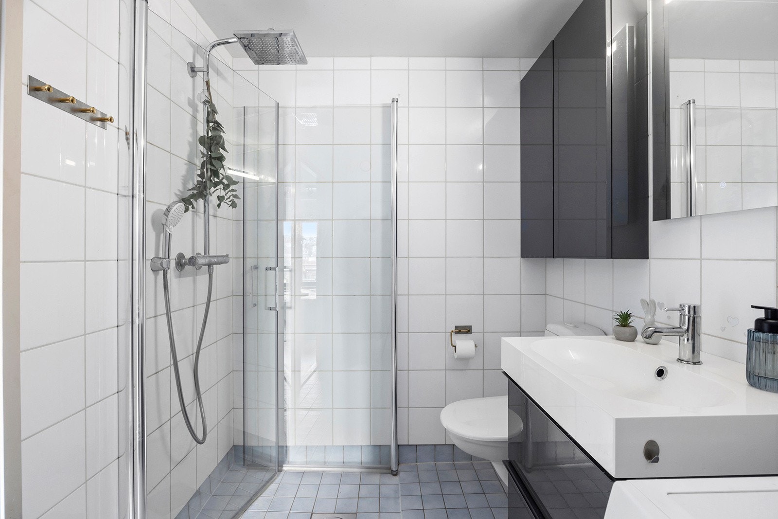 Badet har dusj med regndusj, varmekabler i gulv og opplegg til vaskemaskin Galleribilde