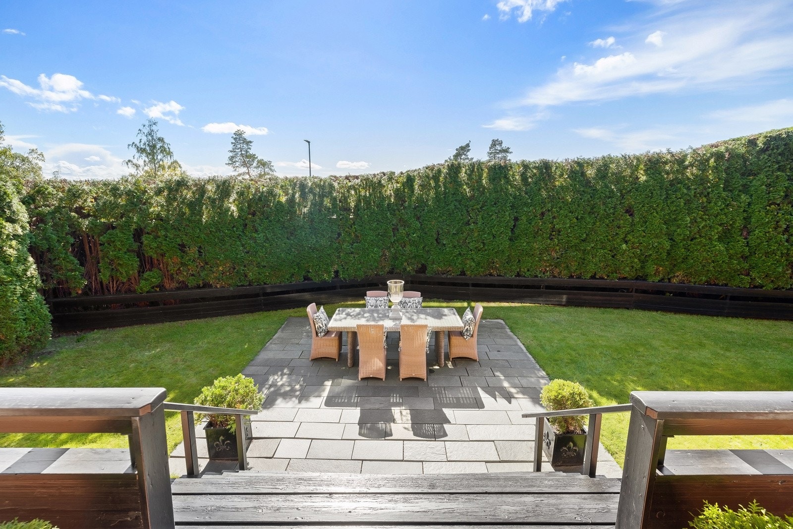 Videre adkomst fra terrassen til hagen, med flott skiferlagt terrasseplatting og pent opparbeidet hage. Galleribilde