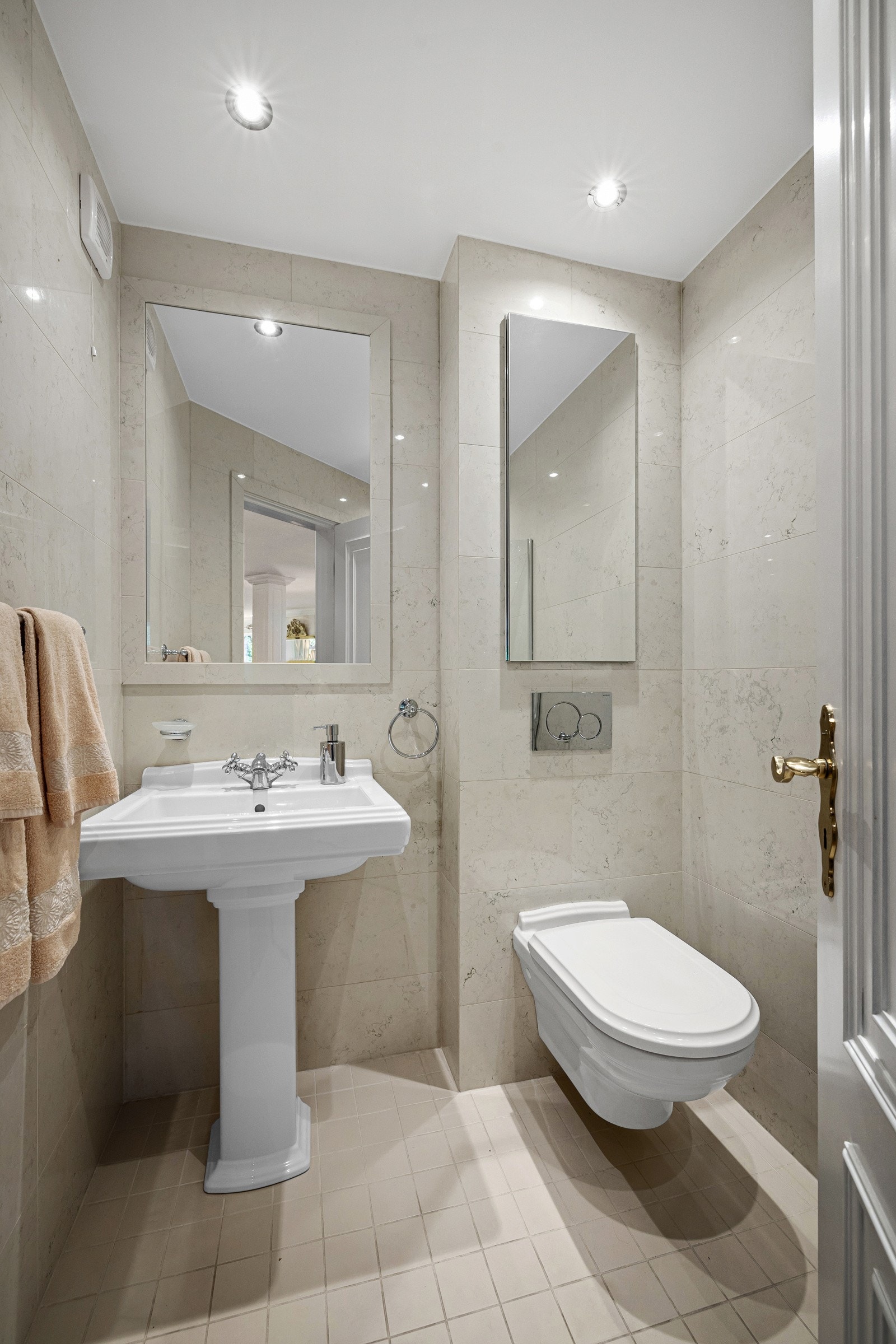 Baderom 3 / gjestetoalett i hovedetasjen. Baderommet har tidløse marmorfliser fliser på veggene og Carrera gulvfliser fra Fired Earth. Galleribilde