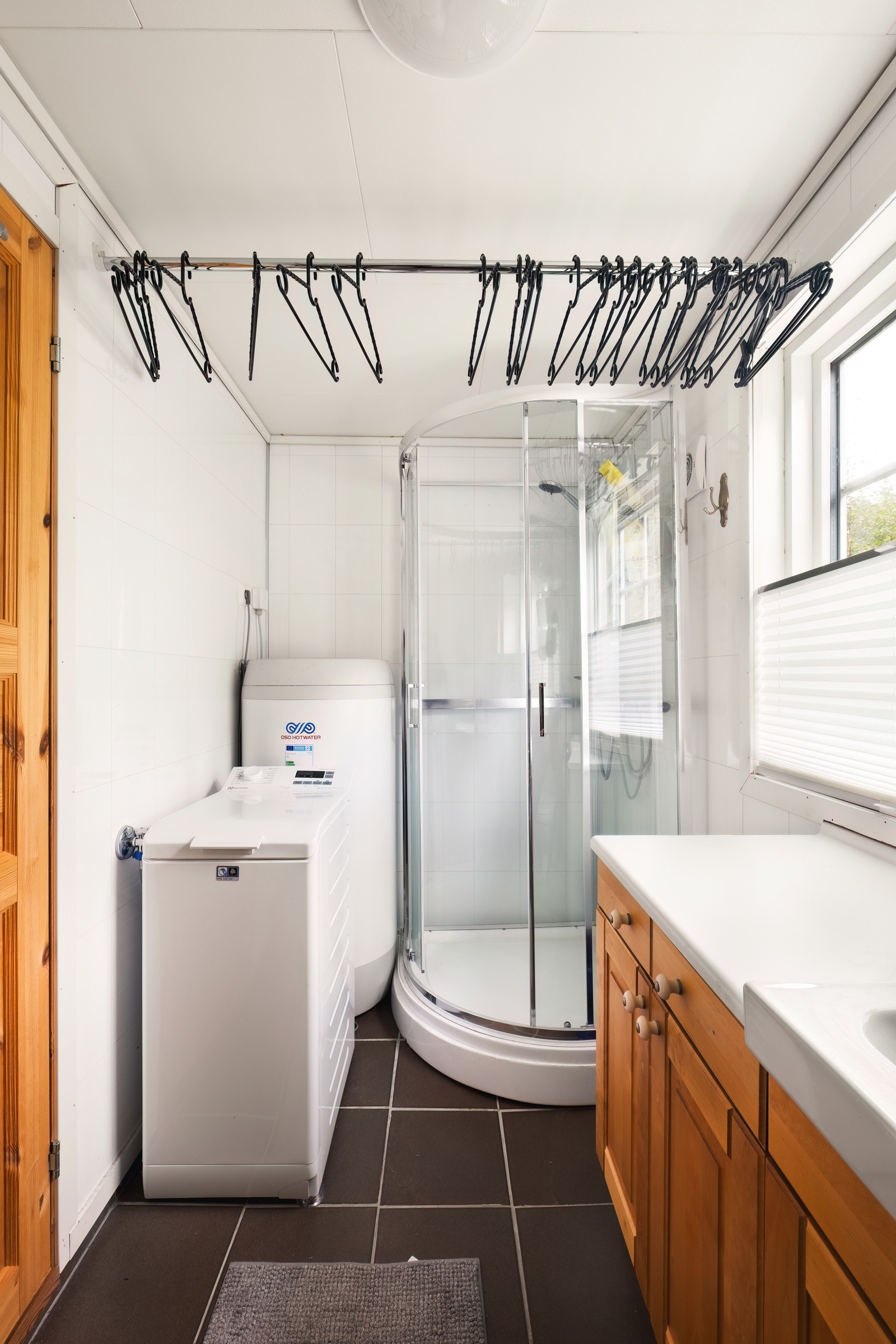 Rommet er innredet med dusjkabinett, toalett og servant med praktisk oppbevaringsløsning. Galleribilde