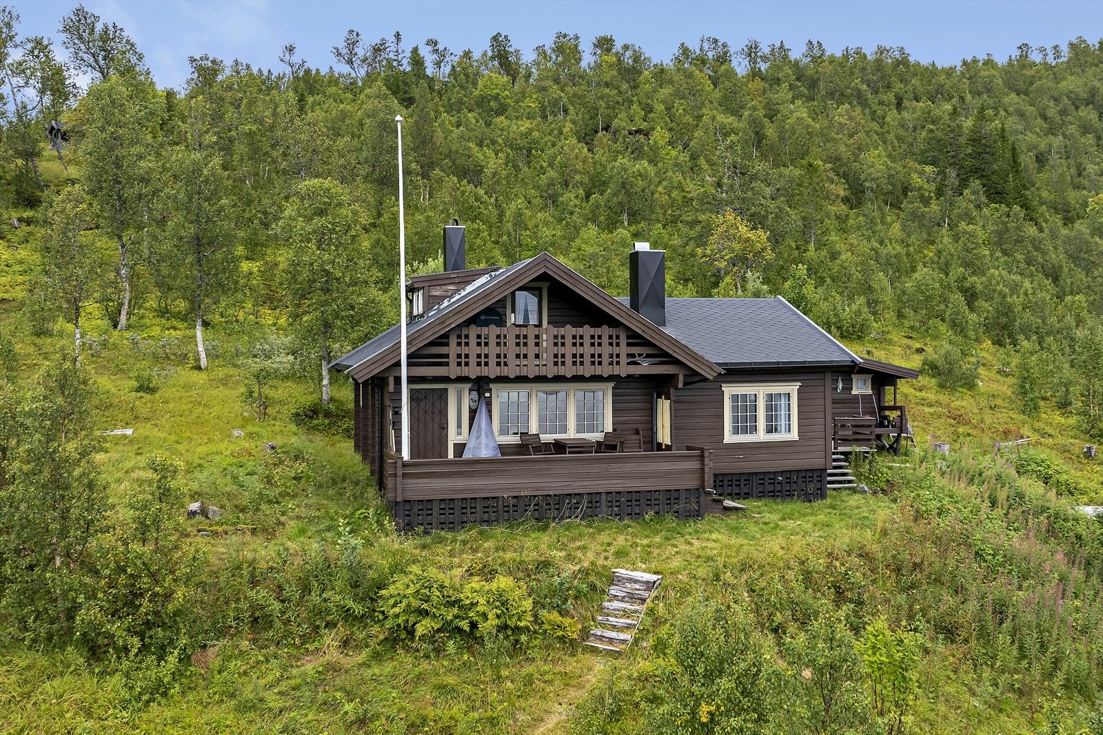 Utvendig er det etablert markterrasser rundt hytta, slik at du kan gå tørrskodd til uthuset på godværsdager. I uthuset finner du badstu, utedo og plass til oppbevaring. Galleribilde