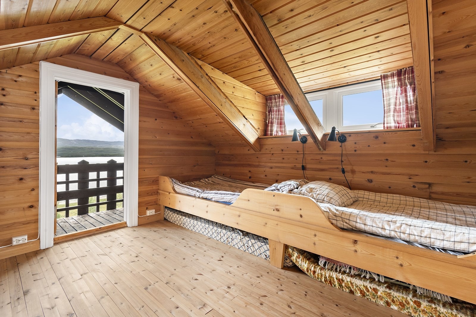 Vi starter på loftet. Fra dette soverommet har du adkomst til en luftebalkong med storslagen utsikt. Galleribilde