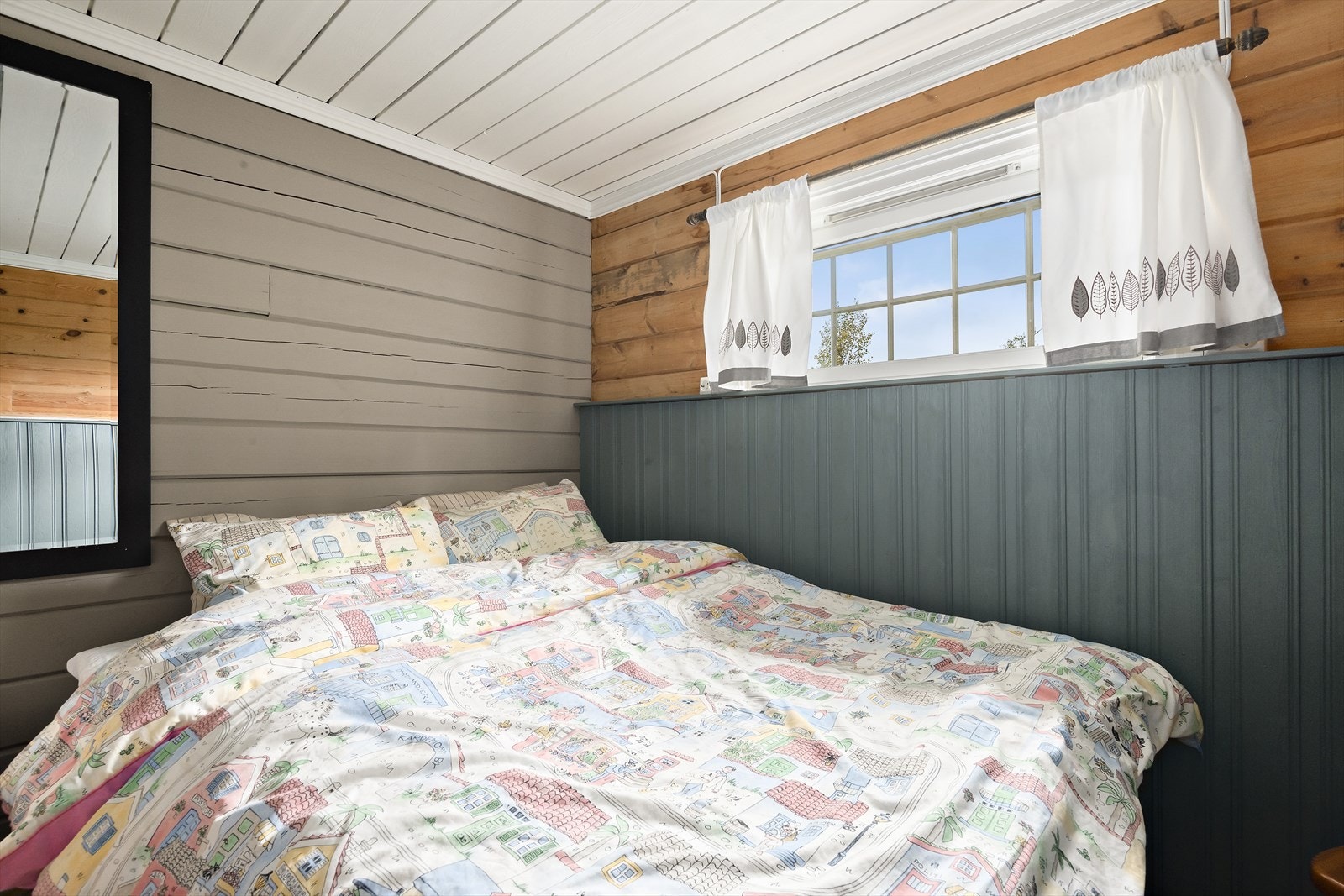 Hovedsoverommet er koselig med en kombinasjon av malt panel, malt tømmer og ubehandlet tømmer. Har har du plass til dobbeltseng. Galleribilde