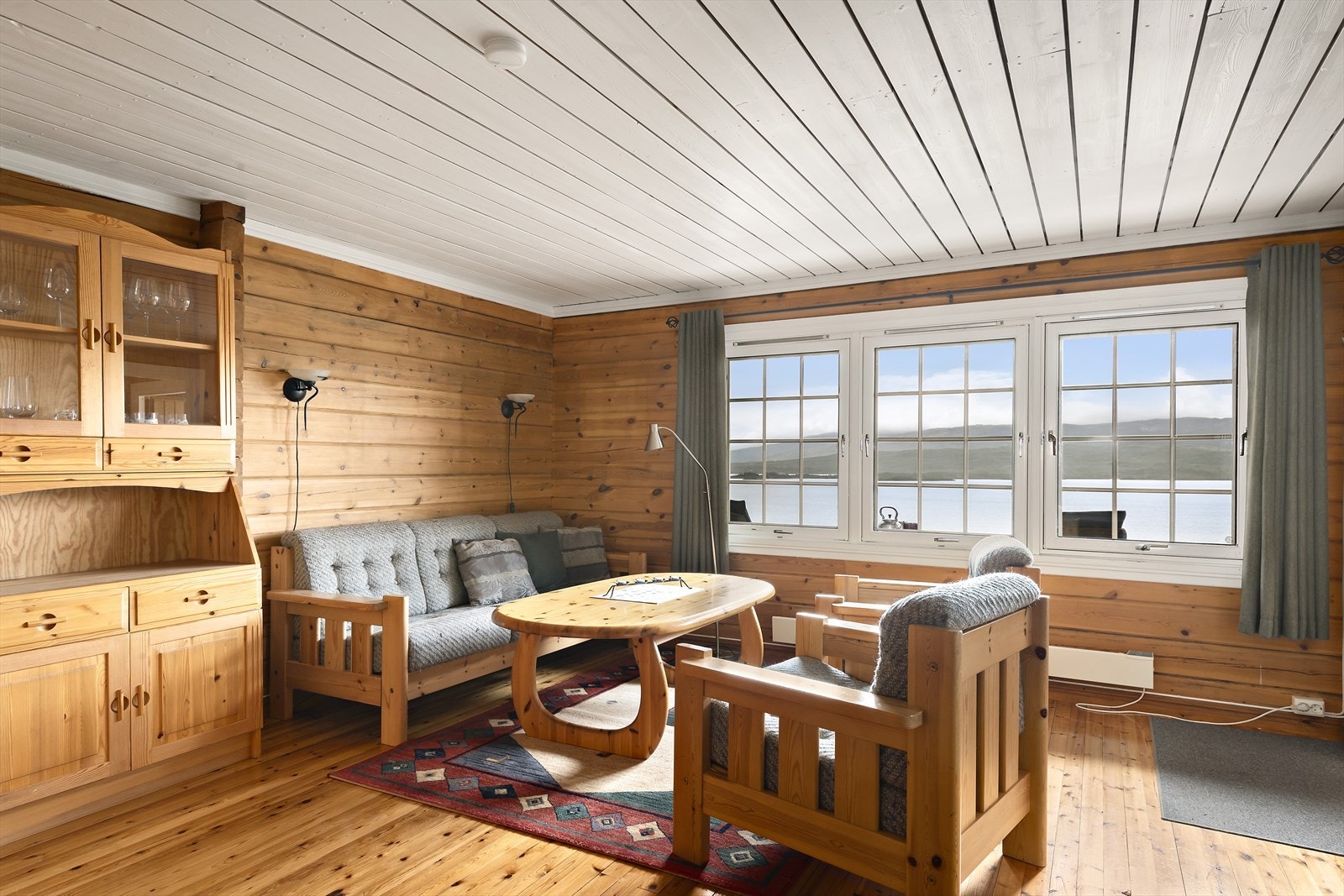 Tømmervegger og gulvflater i heltre furu gir deg den lune hyttefølelsen. Du setter også pris på utsikten ut de store smårutede vinduene. Galleribilde