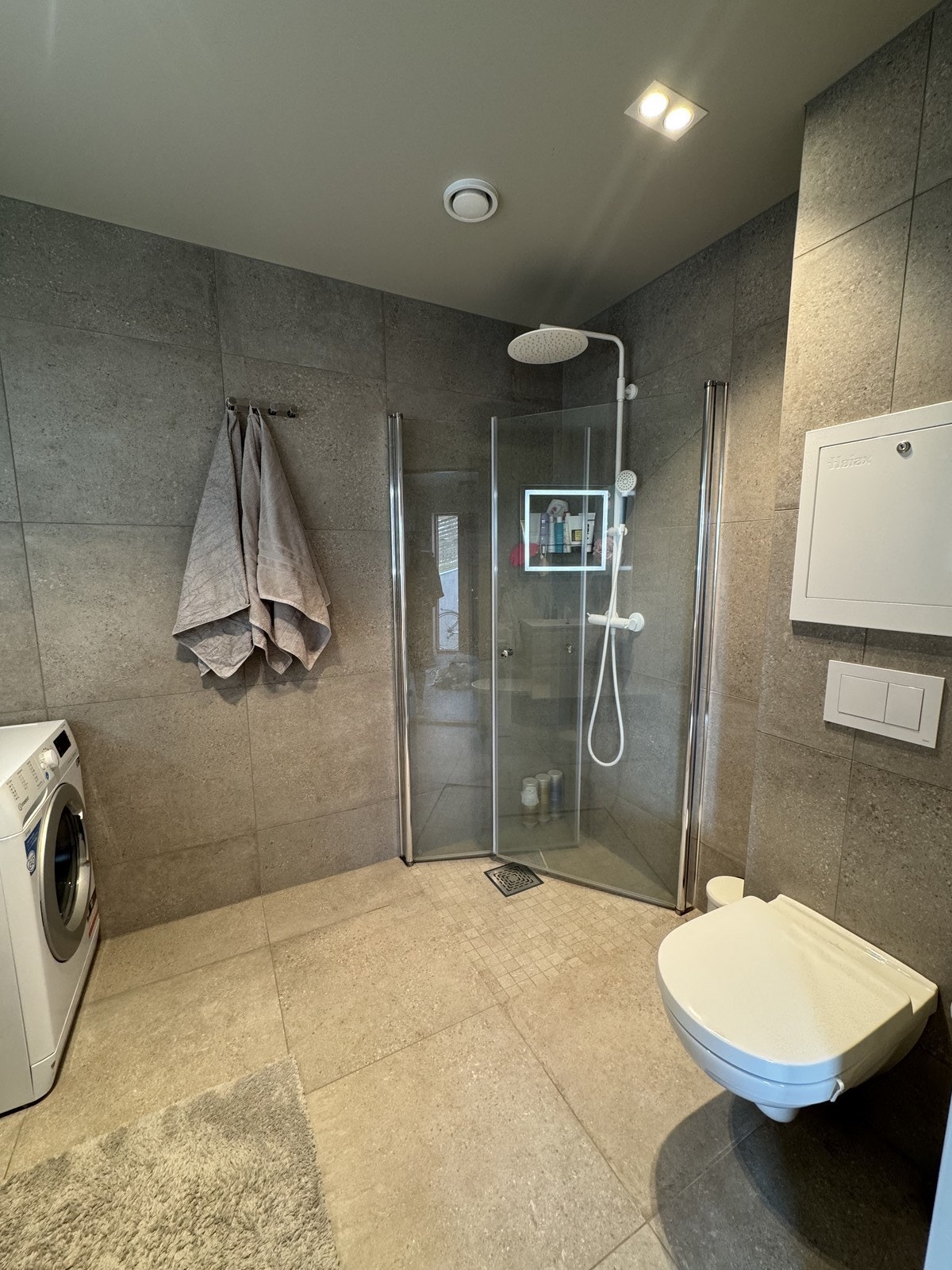 Baderommet har servant med skap og skuffer, vaskemaskin, vegghengt toalett og rainshower dusj. Galleribilde