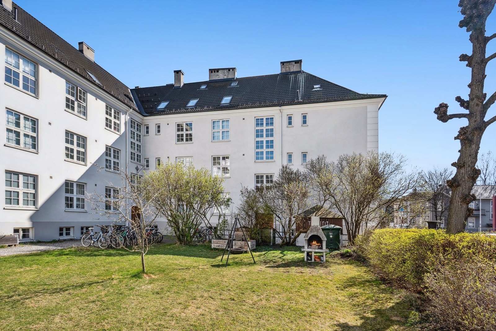 Borettslaget har en flott gressplen i front som gir en tilbaketrukket følelse, og skaper et godt mellomrom mellom veien og bygningen. Galleribilde