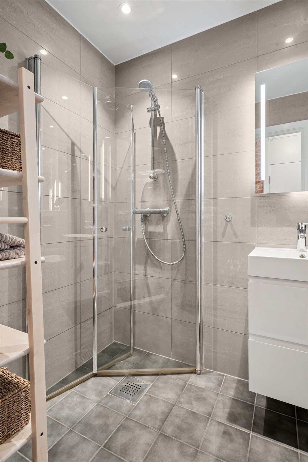 Dusjhjørnet har innfellbare glassdører og veggmontert dusjsett med hånddusj. Opplegg til vaskemaskin. Galleribilde