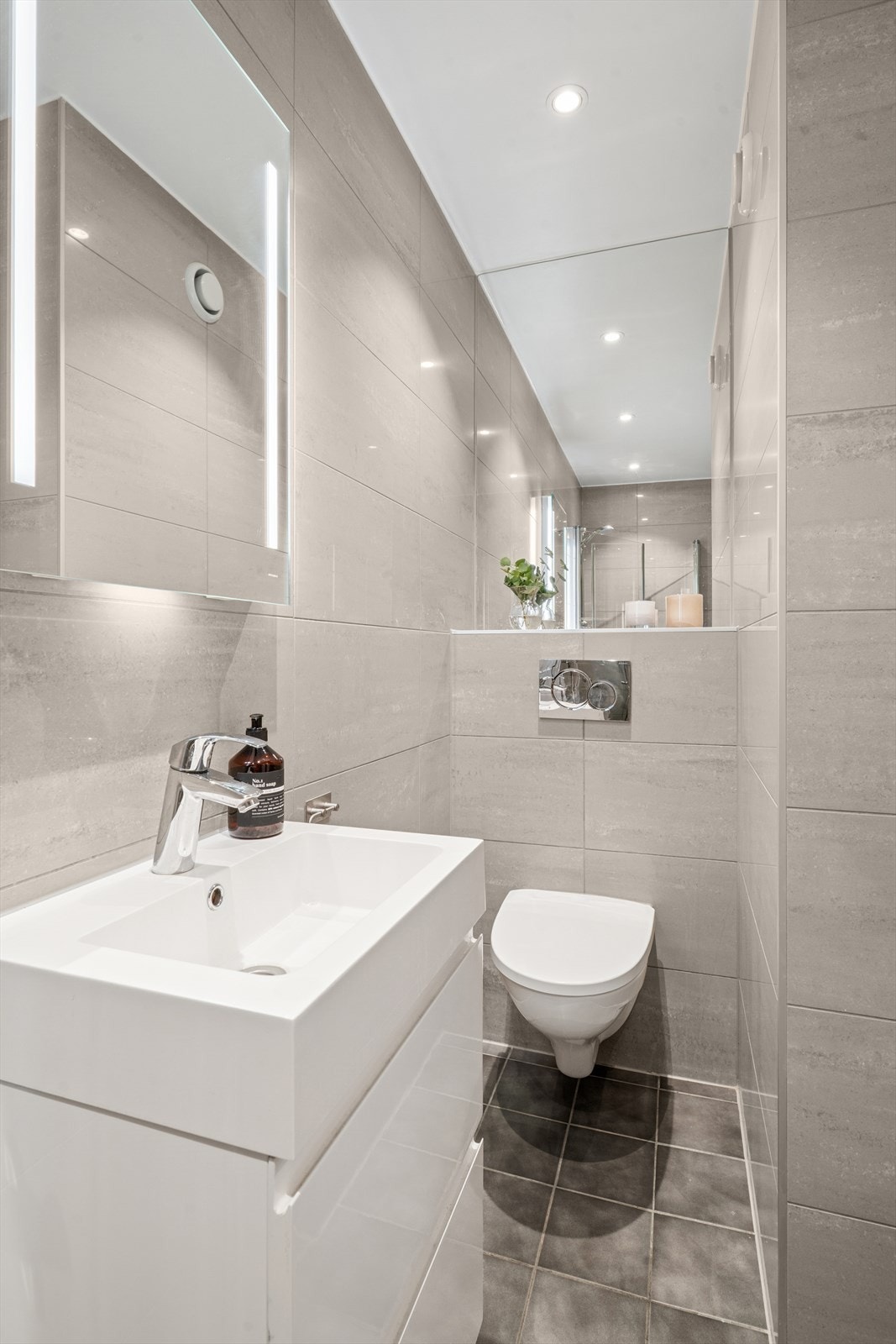 Baderomsinnredningen er praktisk utført med romslige skuffer og heldekkende servant. Over innredningen er det speil med integrert belysning. Galleribilde