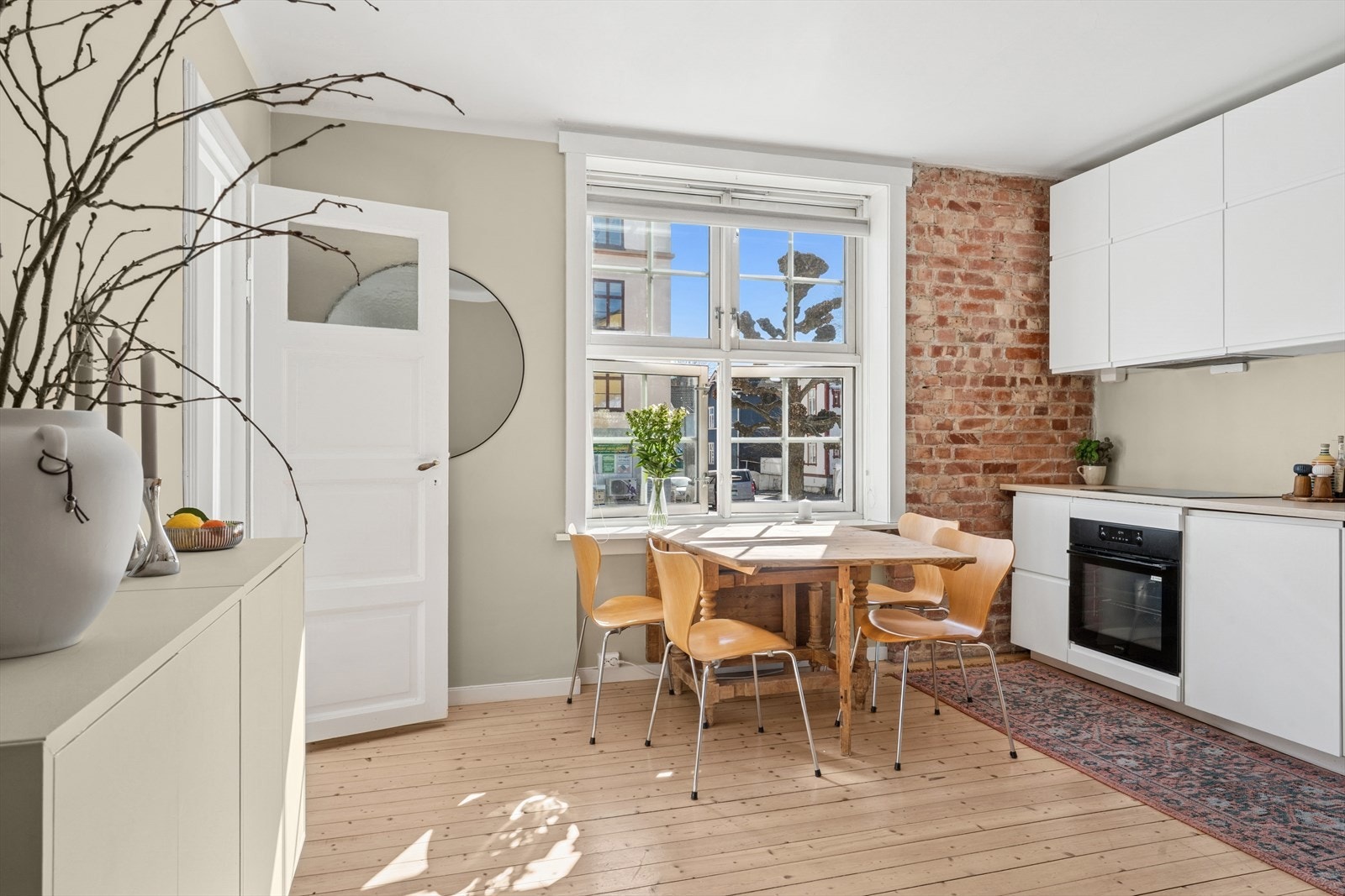 Det store vinduet gir rikelig med naturlig dagslys og skaper en varm og innbydende stemning hele dagen. Galleribilde