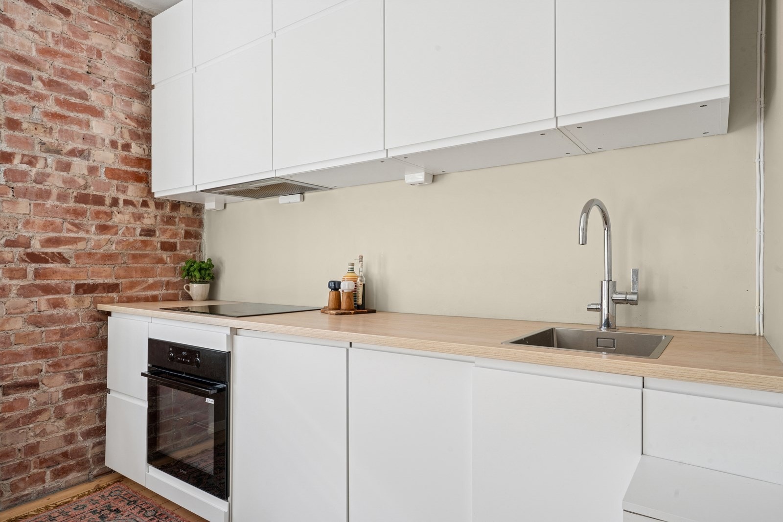 KjøkkenKjøkkeninnredningen er pent utført med hvite, glatte fronter og brun benkeplate. Galleribilde