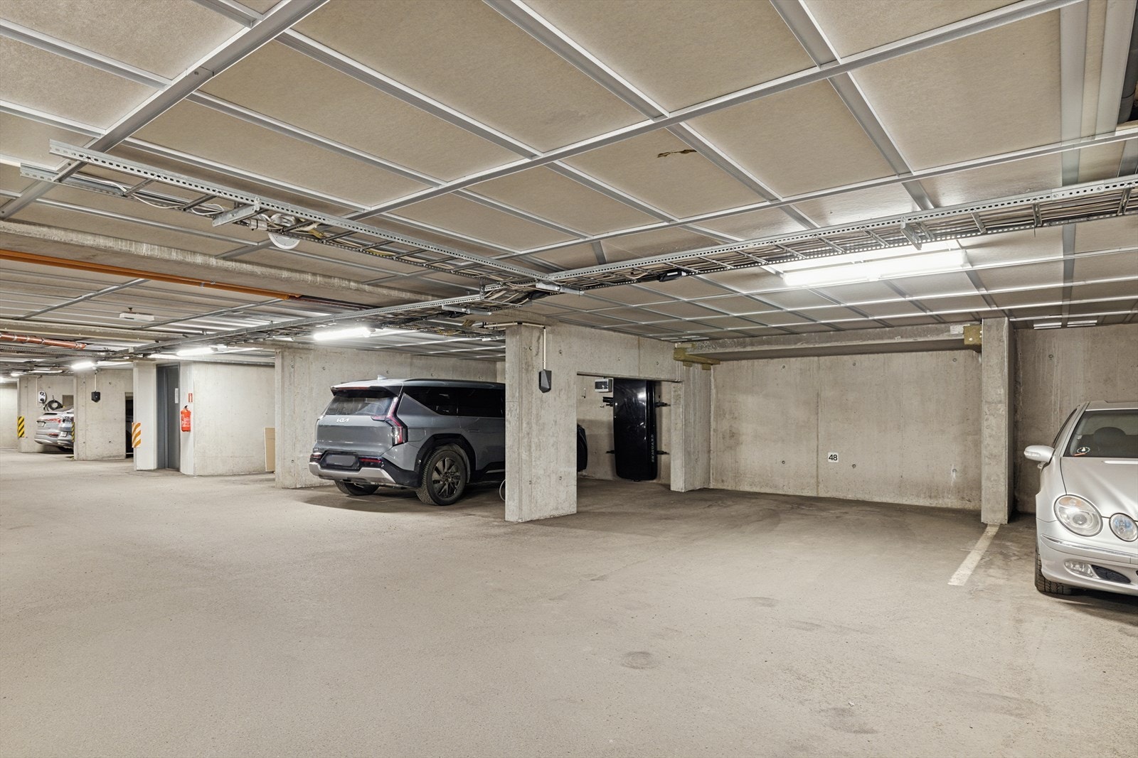 Leiligheten har en ekstra bred garasjeplass under bygget som medfølge. Her er det også installert el-bil lader. Galleribilde