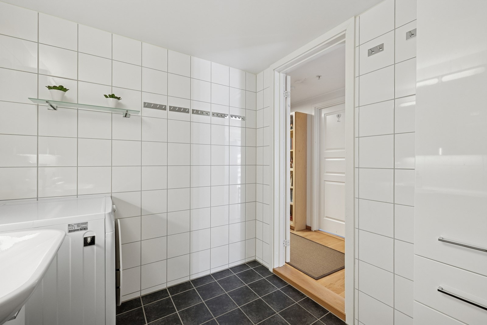 Baderommet er innredet med: Servantskap med høyglans fronter og heldekkende servant. Speilskap med lysarmatur på vegg over servant. Veggmontert klosett. Dusjhjørne med sluk og dusjarmatur på vegg. Galleribilde