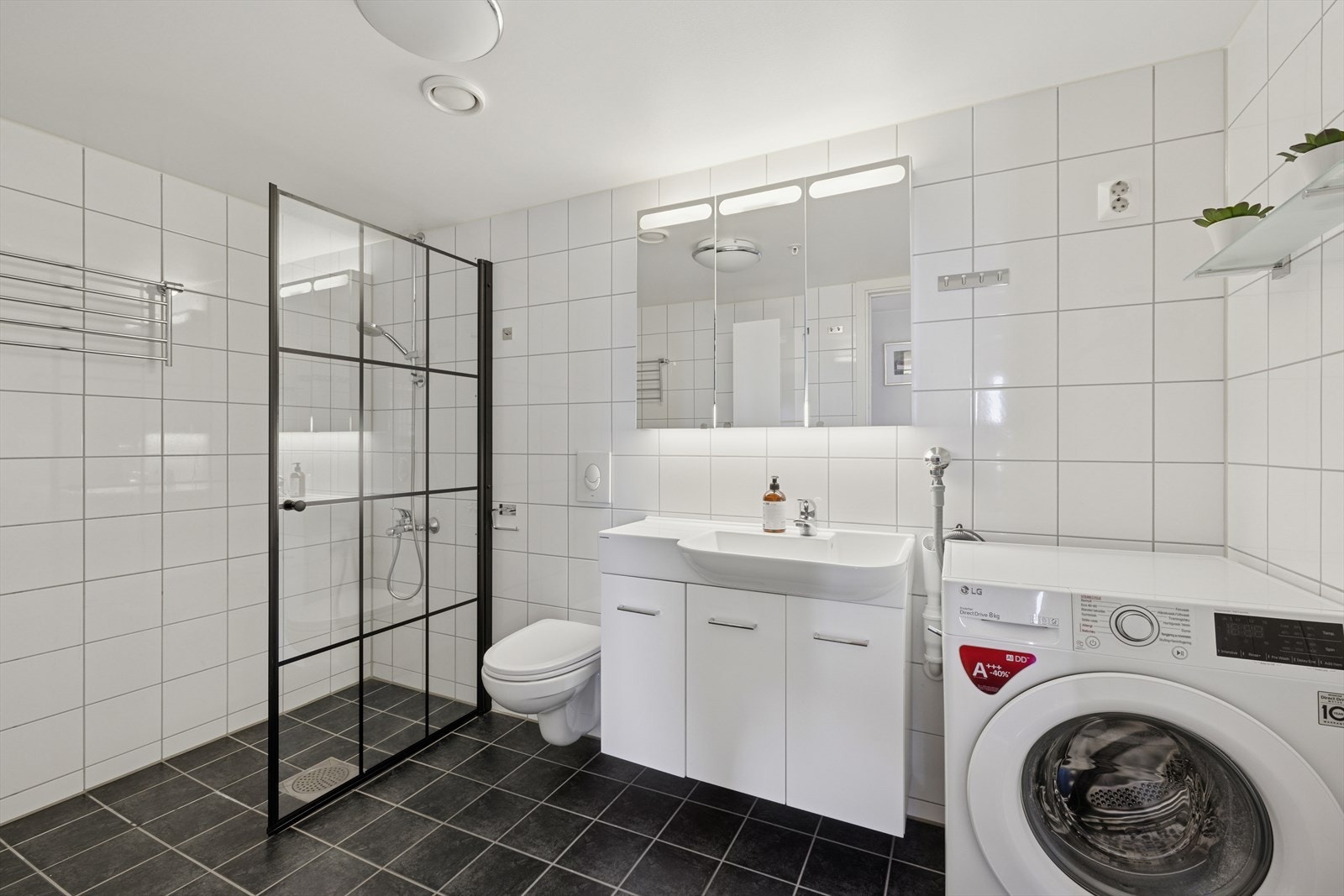 I tilknytning til entreen finner du også boligens baderom. Baderommet er flislagt, med behagelige varmekabler i gulv. Samt praktisk opplegg for vaskemaskin. Galleribilde