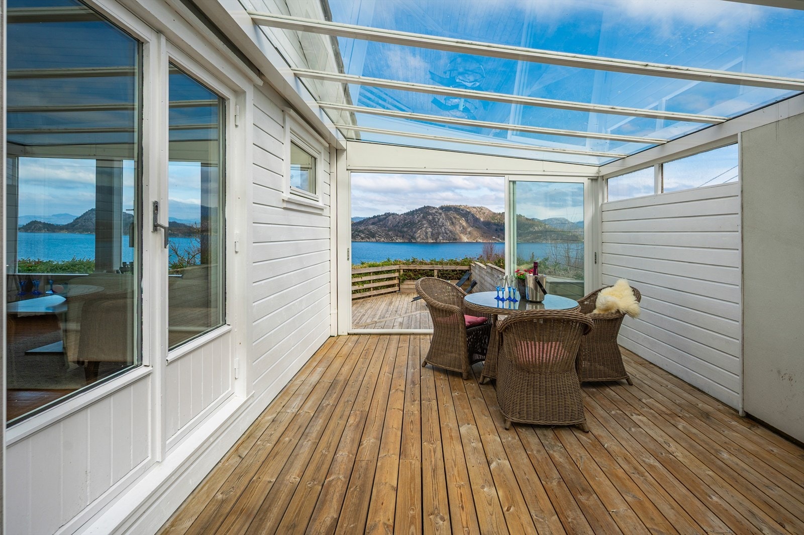 Forestill deg å starte dagen med frokost eller avslutte den med noe godt i glasset i denne innglassede hagestuen - med en enestående utsikt over fjorden. Galleribilde