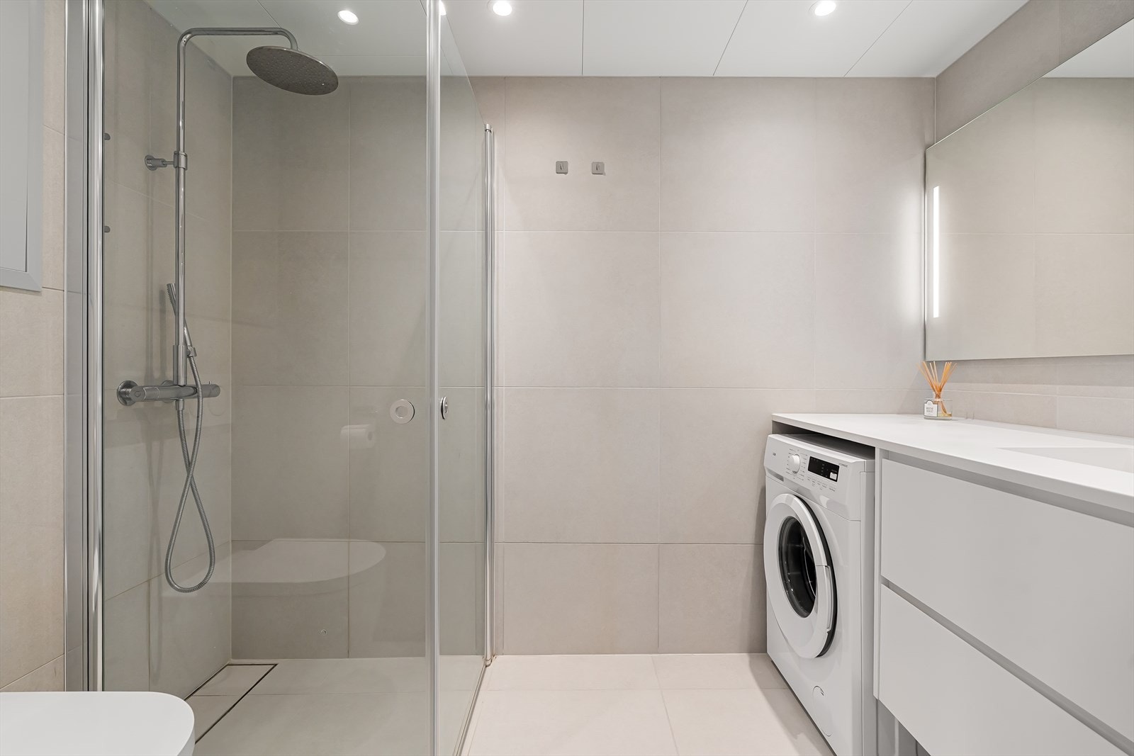 Moderne baderom med store, sandfarvede fliser Galleribilde