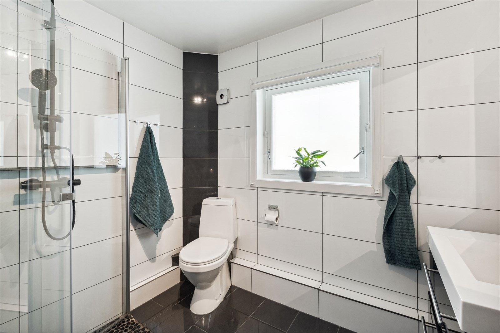 På badet er det også toalett og dusjhjørne med innfellbare glassvegger, noe som er både pent og praktisk. Elektrisk styrt vifte i yttervegg. Galleribilde