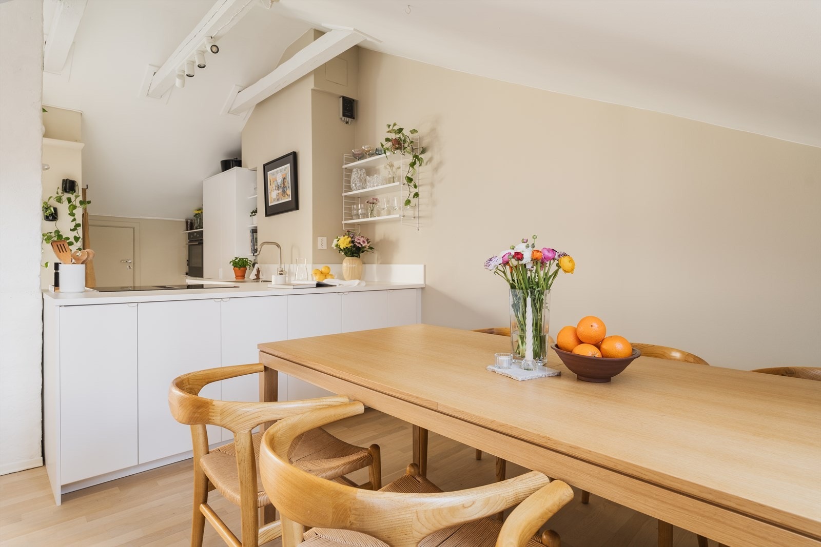 Smart innredet kjøkken med bestikk og servis på spisebordsiden av kjøkkenet, får man i tillegg en ekstra bred benkeplate Galleribilde