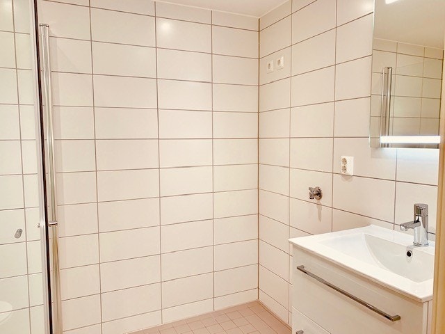 På badet er det dusjhjørne, servant, toalett og opplegg for vaskemaskin Galleribilde