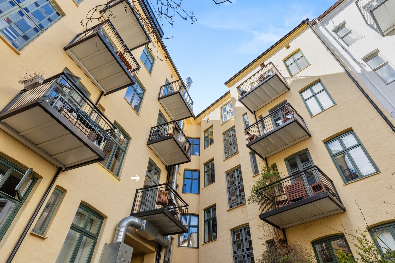 Borettslaget fremstår som godt vedlikeholdt og det er innført IN-ordning med mulighet for nedbetaling av fellesgjelden. Her er bilde fra indre gård opp mot leiligheten som er markert med pil. Galleribilde