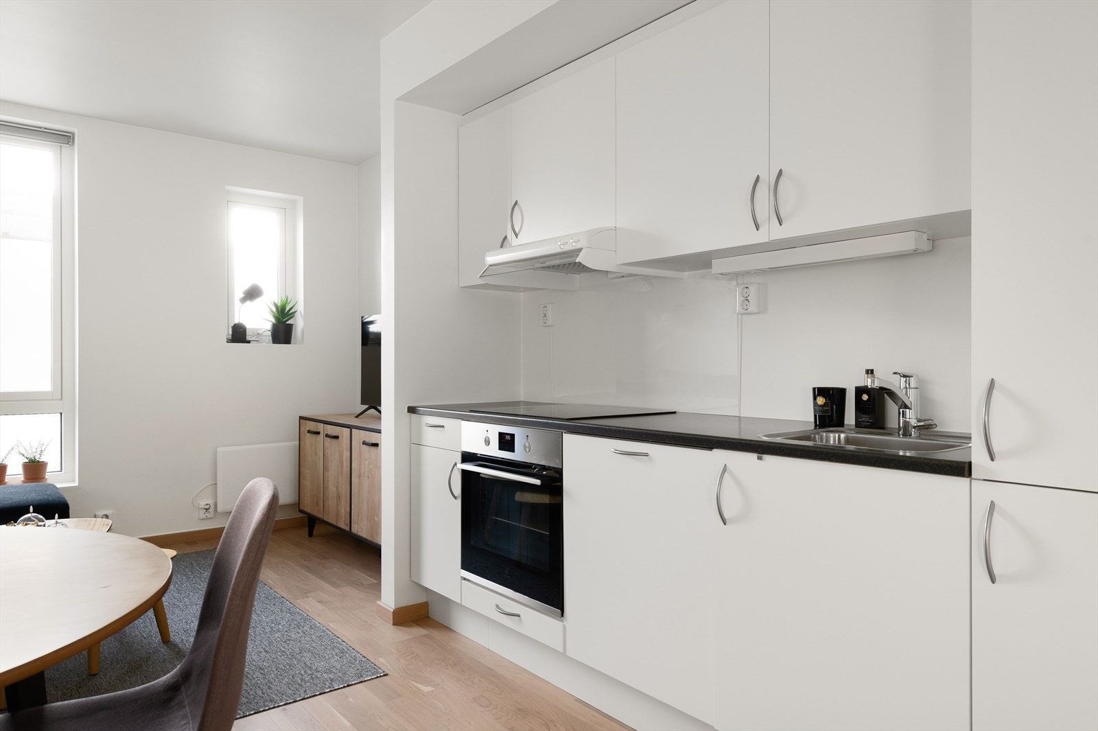 Kjøkkeninnredning med lyse glatte fronter og god skapplass Galleribilde