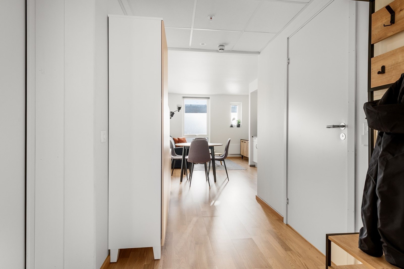 Leilighetens gang gir plass til garderobe for ekstra oppbevaring Galleribilde