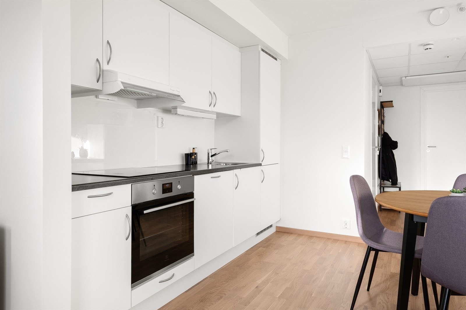 Kjøkkenet er innredet med laminert benkeplate med kjøkkenkum og i integrert stekeovn, koketopp, oppvaskmaskin, kombiskap kjøl/frys. Glass og belysning i over benkeplate Galleribilde