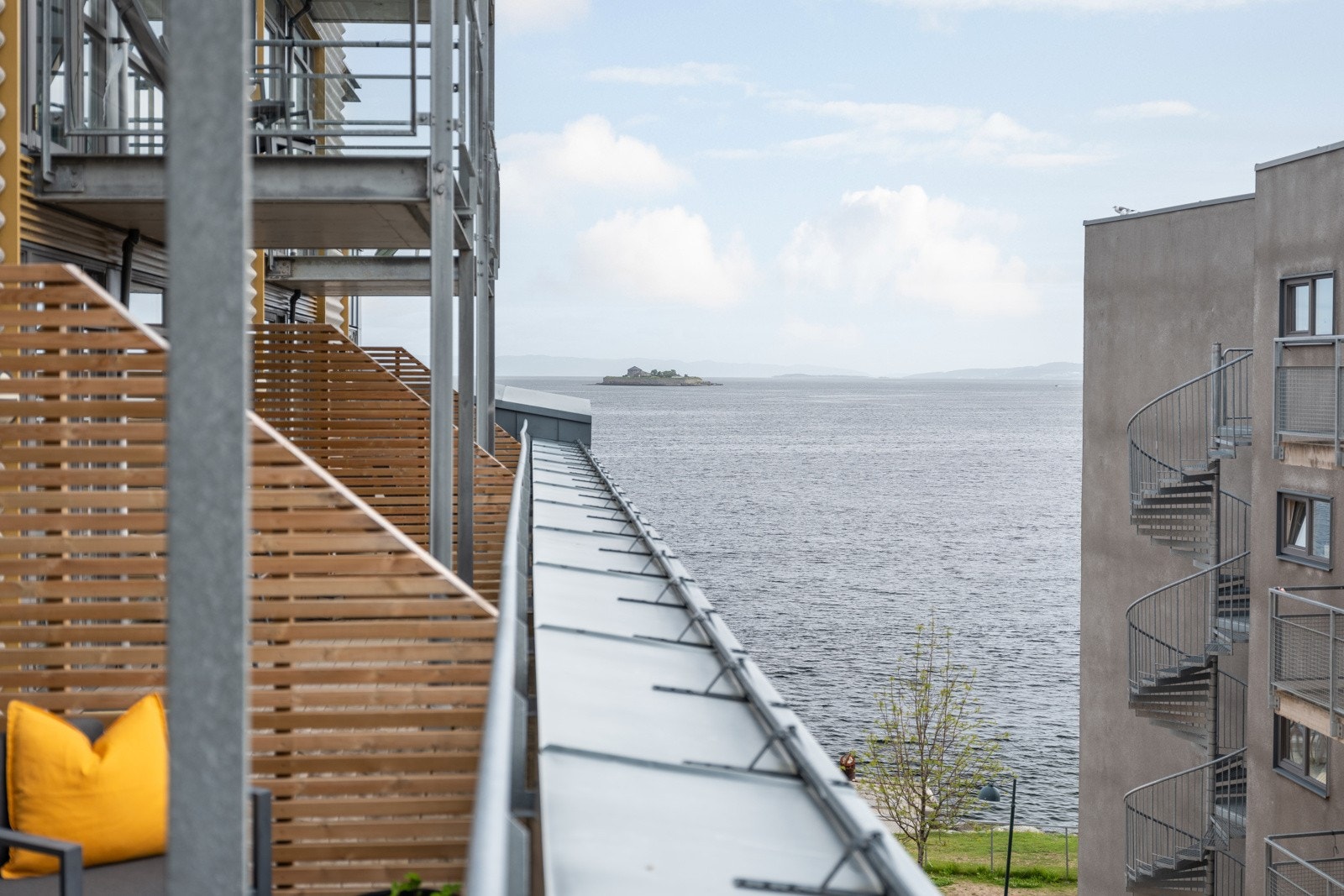 Fra terrassen har man nydelig utsikt mot Trondheimsfjorden og Munkholmen. Nye skillevegger mellom balkonger ble etablert i 2023, samtidig ble dekket beiset. Galleribilde